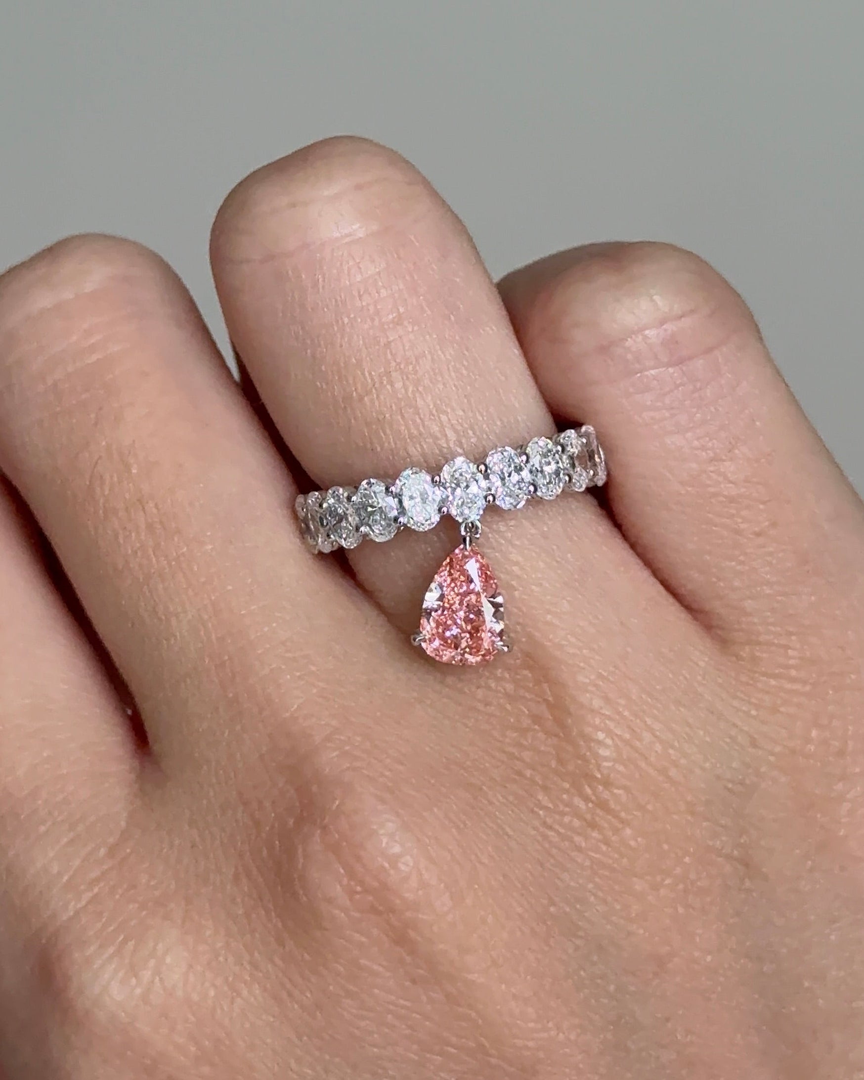 The Reserve II 1 carat Fancy Vivid Pink Pear Cut Diamond with 15 Pointer Oval Half Eternity Ring