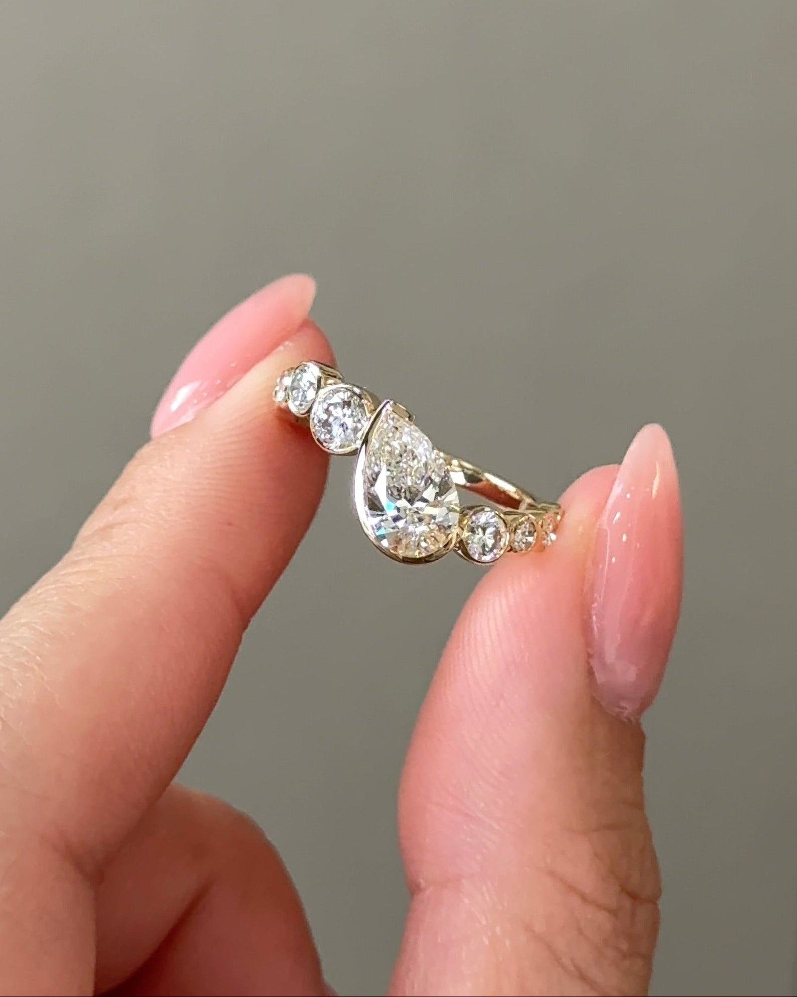 1 carats Pear cut Diamond Bezel Arc Ring with Round Accents